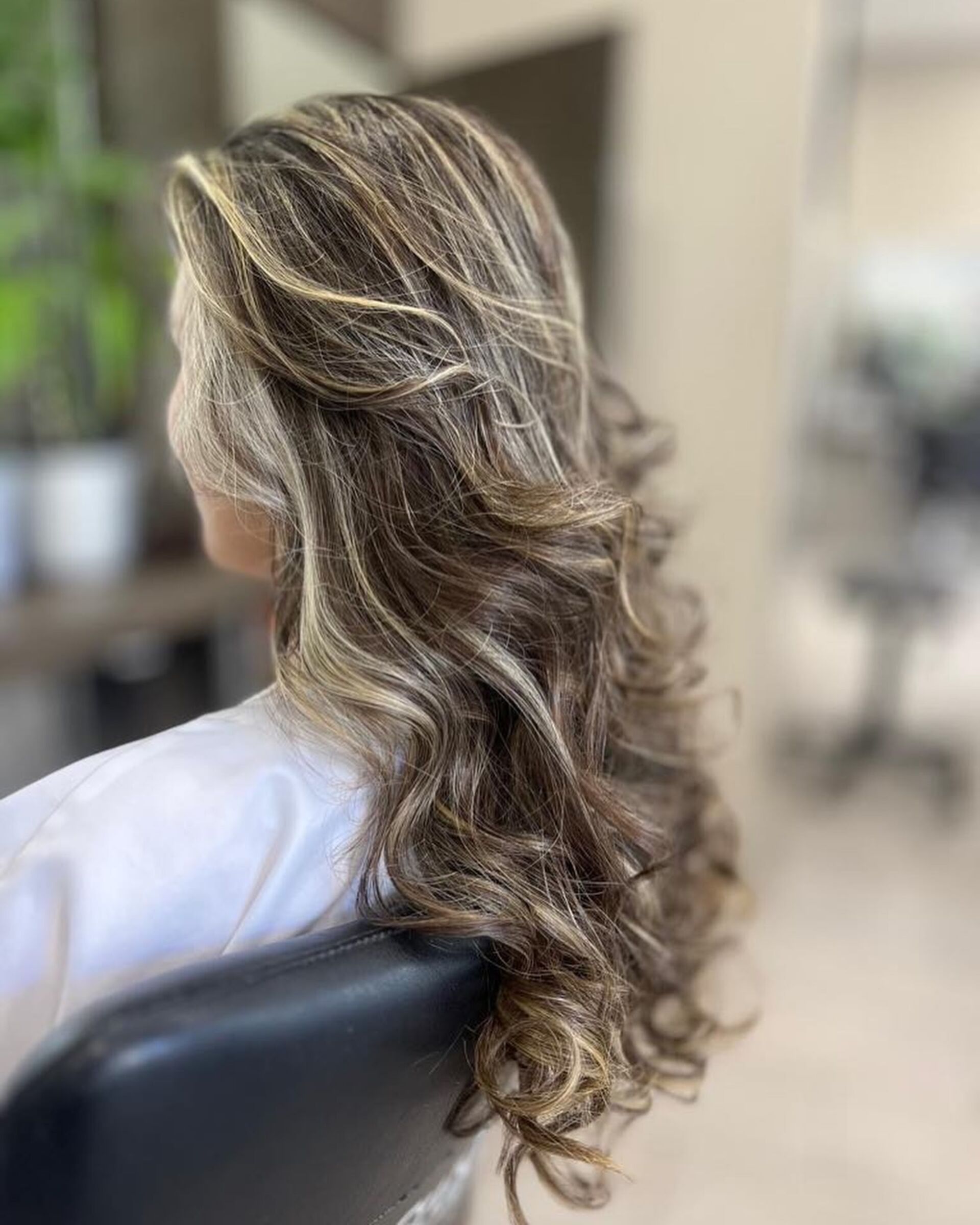 Cheveux longs ondulés sublimés par les coiffeurs Studio 129